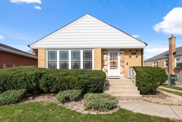 bungalow-style house featuring brick siding and central AC