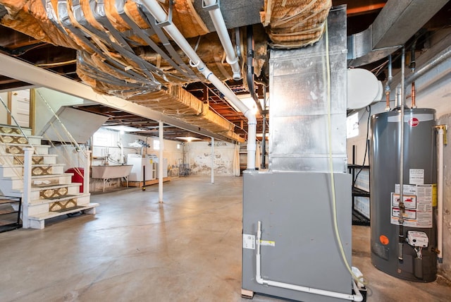 basement featuring heating unit, a sink, stairs, and water heater