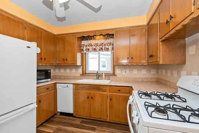 kitchen featuring a sink, light countertops, ceiling fan, white appliances, and dark wood finished floors
