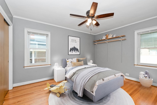bedroom featuring ornamental molding, light wood-type flooring, and multiple windows