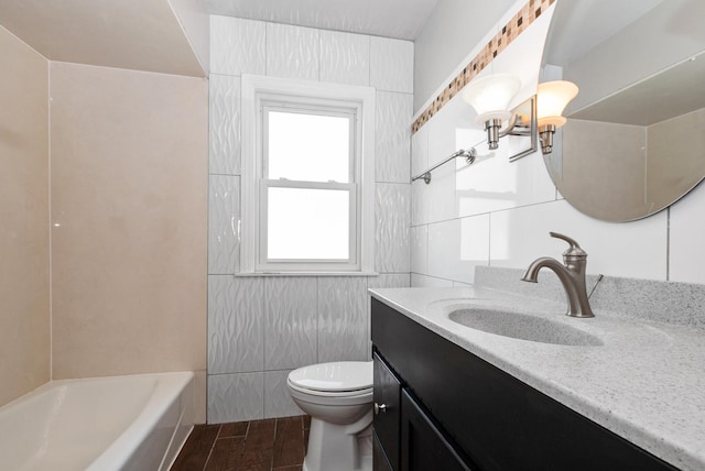 full bathroom with tile walls, toilet, vanity, and wood finished floors