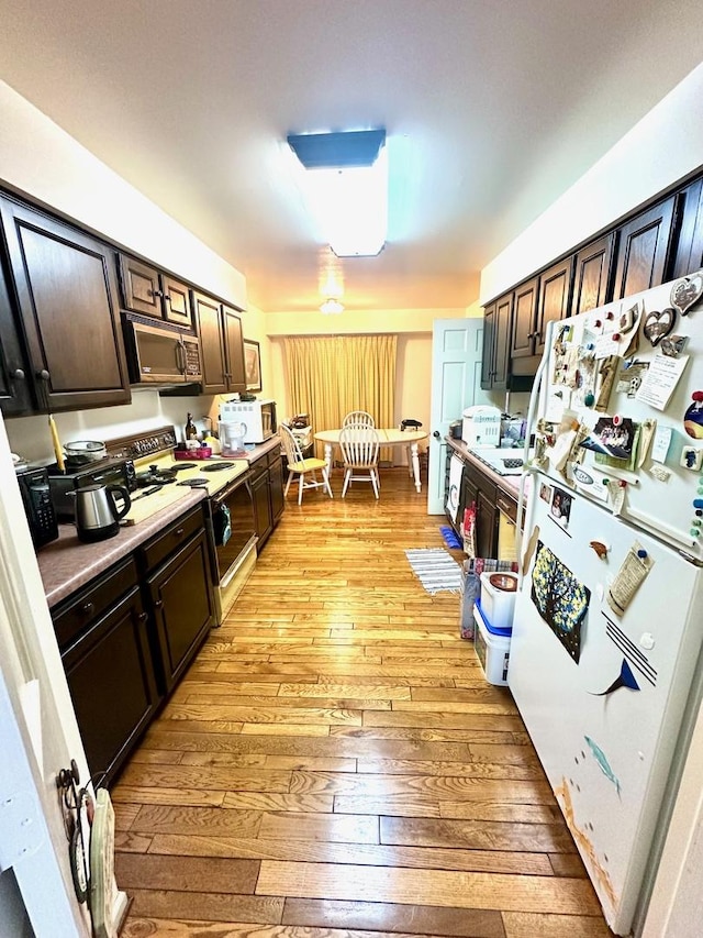 1927 Mission Hills Ln, Northbrook, IL 60062 - kitchen with freestanding refrigerator, stainless steel microwave, light wood-type flooring, electric stove, and dark brown cabinetry