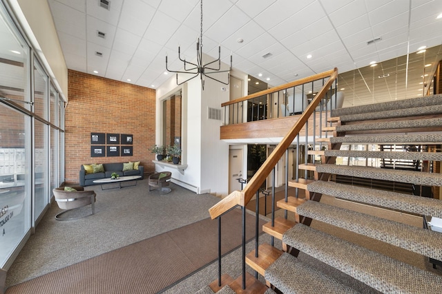 4221 Saratoga Ave Unit 310-A, Downers Grove, IL 60515 - stairs featuring visible vents, a high ceiling, brick wall, and a paneled ceiling