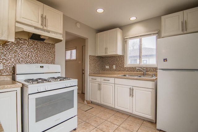 1344 Superior Ave, Calumet City, IL 60409 - kitchen featuring white appliances, light tile patterned floors, a sink, under cabinet range hood, and white cabinetry