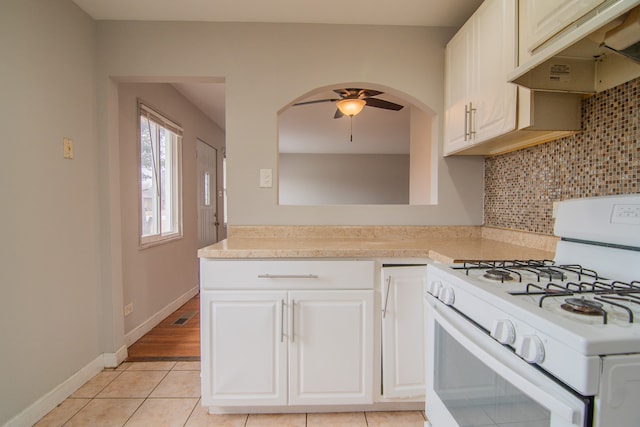 1344 Superior Ave, Calumet City, IL 60409 - kitchen with under cabinet range hood, white gas range, a ceiling fan, and light countertops