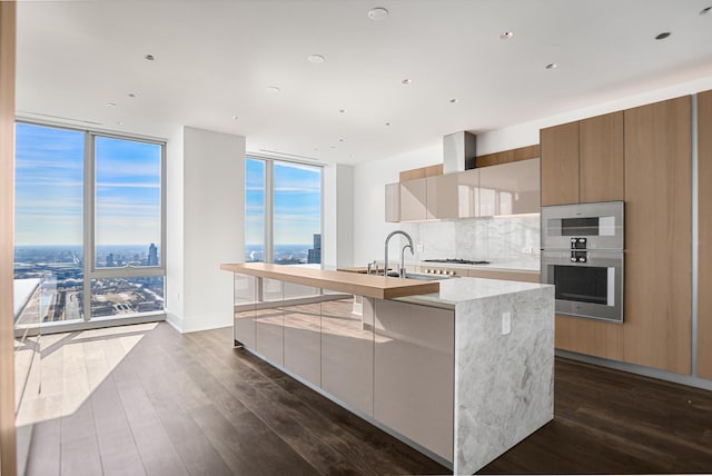 363 E Wacker Dr Unit 6306, Chicago, IL 60601 - kitchen featuring modern cabinets, a wall of windows, a sink, a kitchen island with sink, and tasteful backsplash
