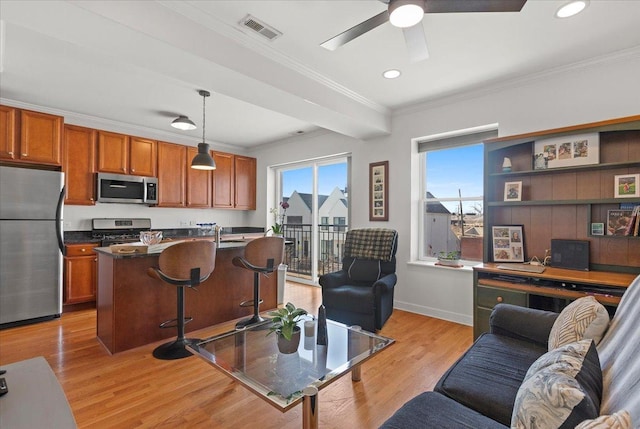 living area with visible vents, ceiling fan, light wood-style floors, and ornamental molding