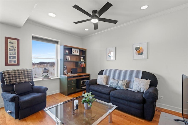 living room featuring baseboards, light wood-type flooring, a ceiling fan, and ornamental molding