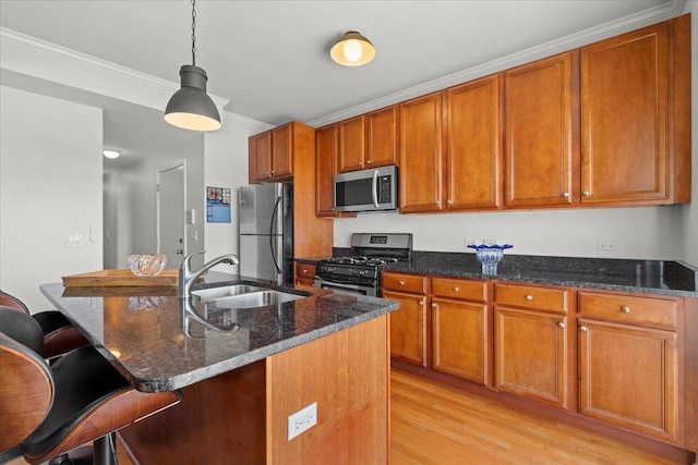 kitchen featuring a sink, brown cabinetry, light wood finished floors, and stainless steel appliances