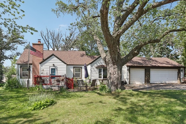 7616 Orchard Rd, Wonder Lake, IL 60097 - view of front of property featuring a front lawn, a chimney, a garage, a deck, and a shingled roof