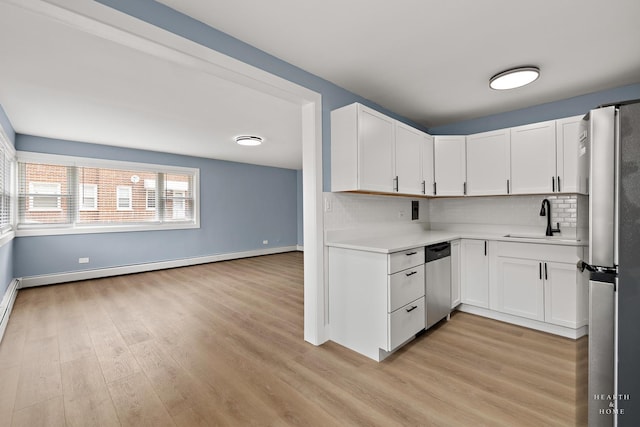 2411 W Balmoral Ave Unit 1F, Chicago, IL 60625 - kitchen featuring stainless steel appliances, light countertops, light wood-style flooring, decorative backsplash, and white cabinetry