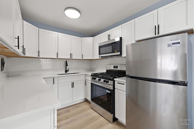 2411 W Balmoral Ave Unit 1F, Chicago, IL 60625 - kitchen with stainless steel appliances, white cabinets, and light wood finished floors