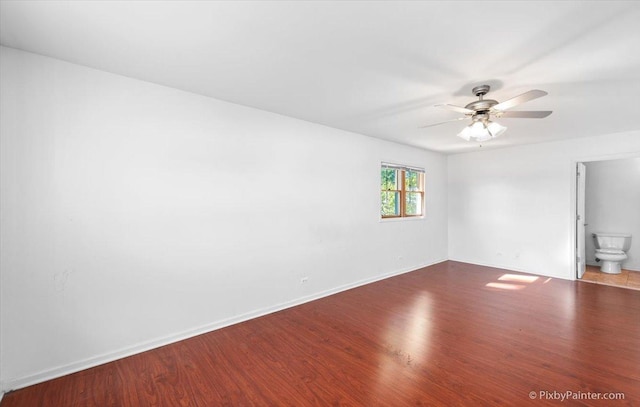 empty room featuring a ceiling fan, baseboards, and wood finished floors
