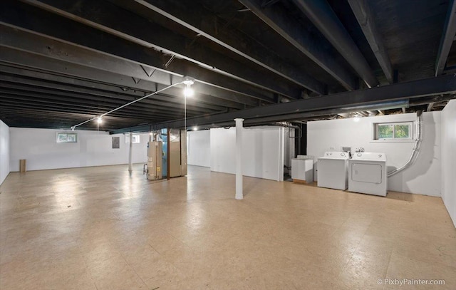 basement with water heater, tile patterned floors, and washer and clothes dryer