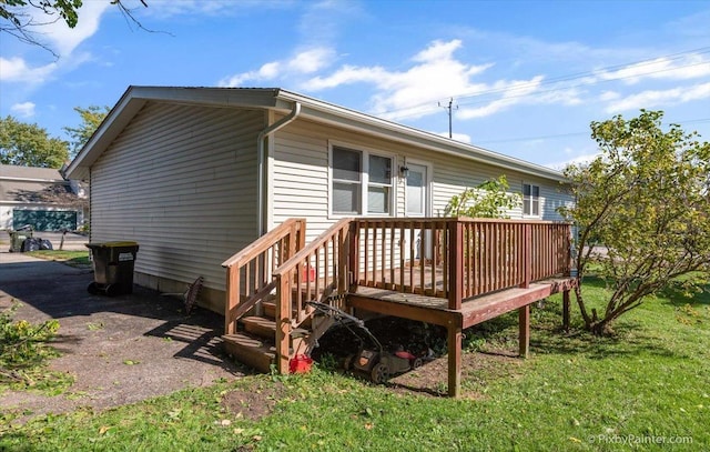 back of house featuring a deck and a yard