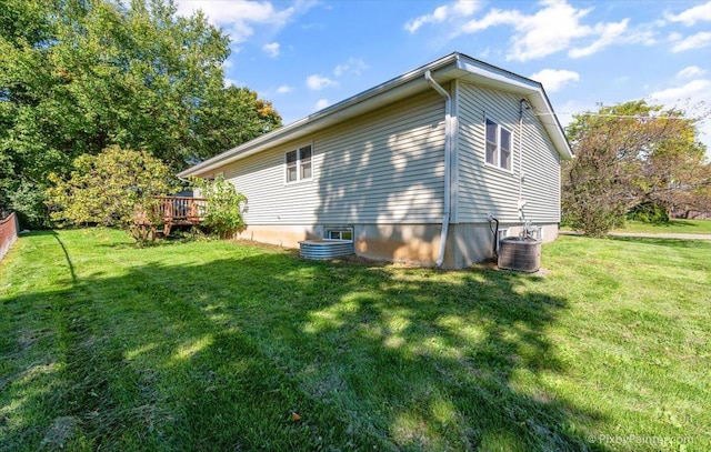 view of side of property featuring cooling unit and a yard
