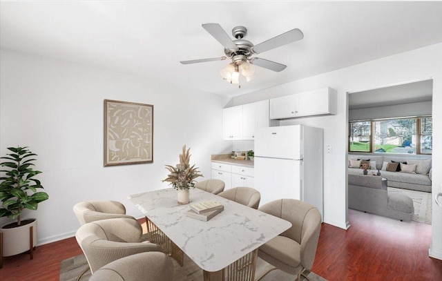dining room featuring baseboards, a ceiling fan, and dark wood-style flooring