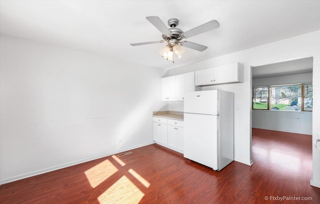 kitchen with dark wood finished floors, white cabinetry, ceiling fan, and freestanding refrigerator