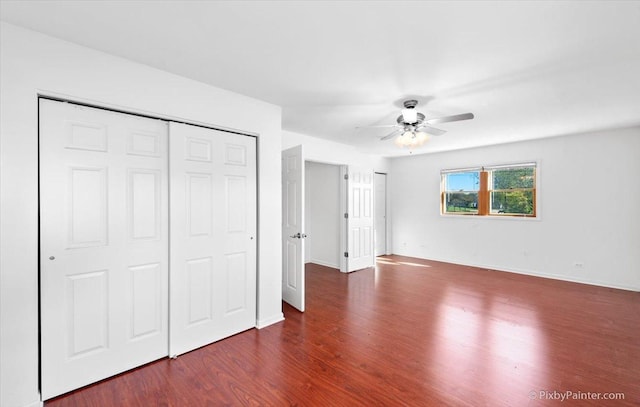 unfurnished bedroom with baseboards, ceiling fan, and dark wood-type flooring