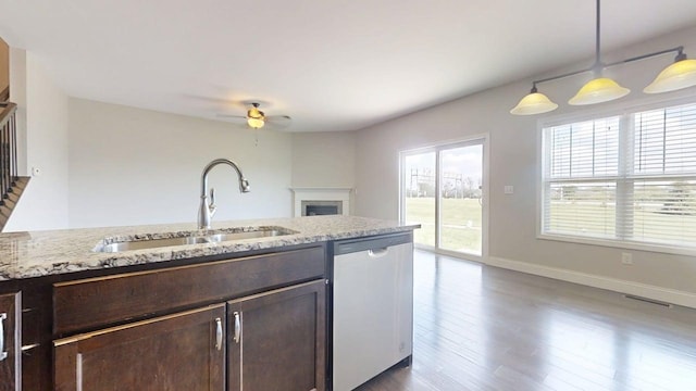 750 Sedgegrass Dr, Champaign, IL 61822 - kitchen with dishwasher, a sink, dark brown cabinetry, ceiling fan, and a fireplace