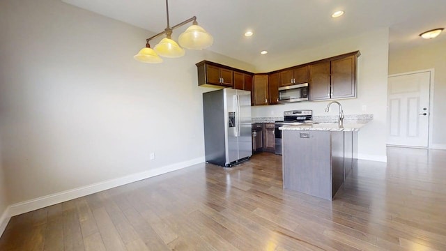 750 Sedgegrass Dr, Champaign, IL 61822 - kitchen featuring appliances with stainless steel finishes, baseboards, a peninsula, wood finished floors, and pendant lighting