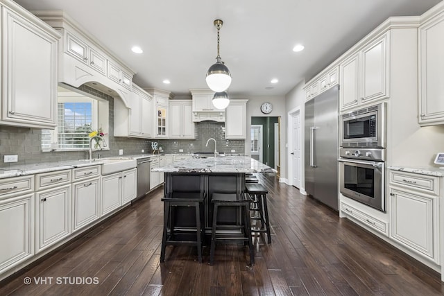 6 Shenandoah Cir S, Barrington, IL 60010 - kitchen with light stone counters, decorative backsplash, a sink, built in appliances, and an island with sink