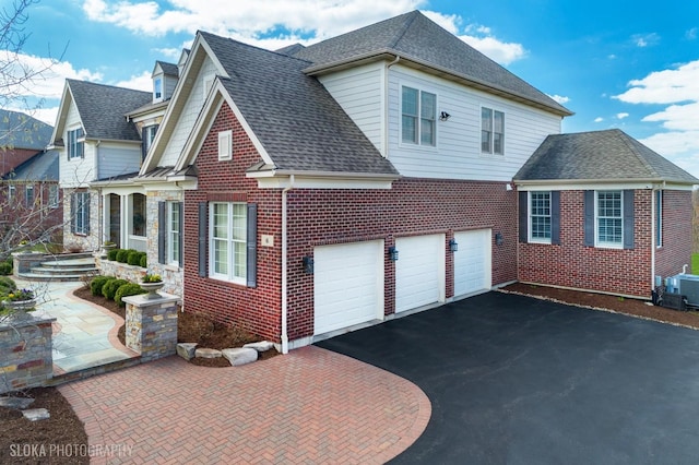 6 Shenandoah Cir S, Barrington, IL 60010 - view of side of property with driveway, a shingled roof, central air condition unit, an attached garage, and brick siding