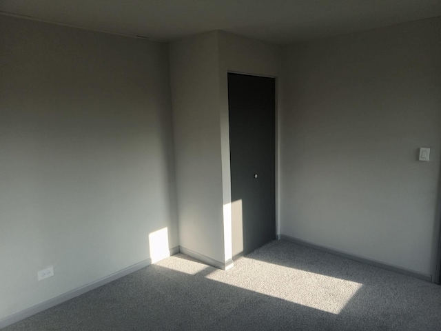 carpeted empty room with baseboards
