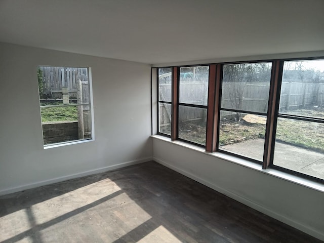 spare room with baseboards and plenty of natural light