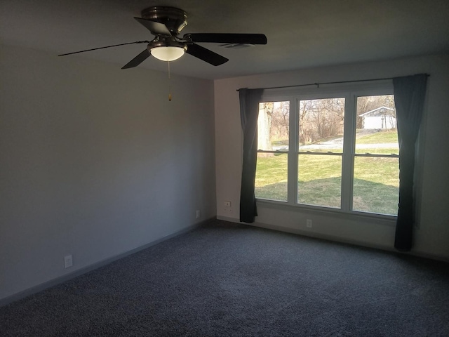 carpeted spare room with visible vents, baseboards, and ceiling fan