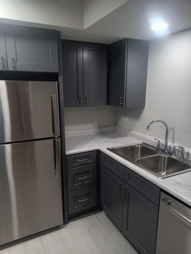 kitchen with stainless steel appliances, light countertops, and a sink