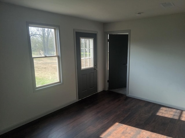 interior space with dark wood-type flooring and baseboards