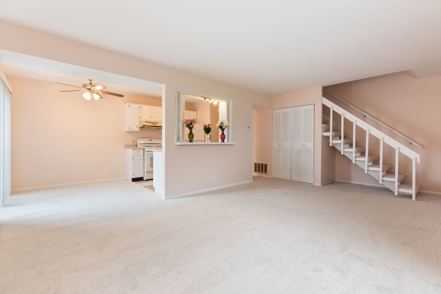 unfurnished living room featuring light carpet, stairs, a ceiling fan, baseboards, and visible vents