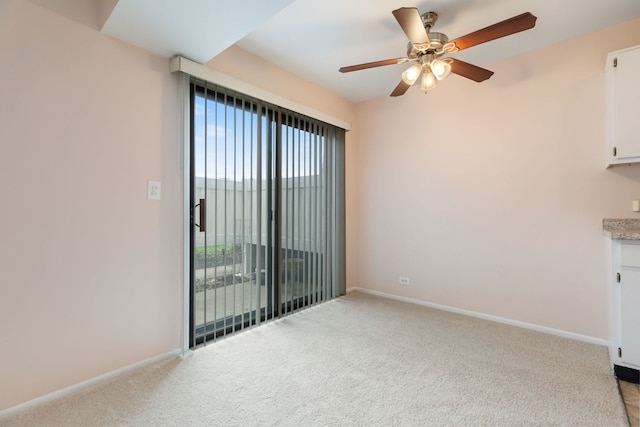 unfurnished room featuring light colored carpet, a ceiling fan, and plenty of natural light