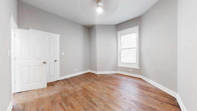 spare room with visible vents, wood finished floors, and baseboards