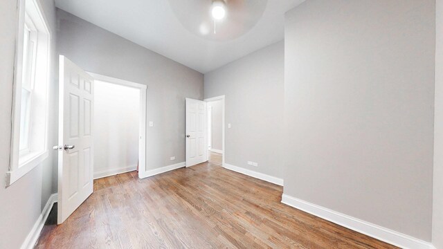 unfurnished bedroom with baseboards, light wood-style floors, and a ceiling fan
