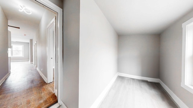 hall featuring baseboards and wood finished floors