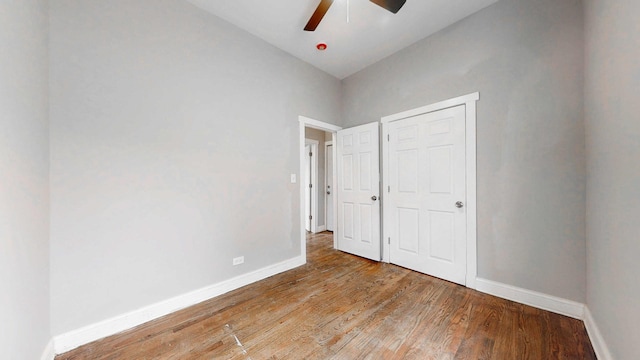 unfurnished bedroom featuring ceiling fan, baseboards, and wood finished floors
