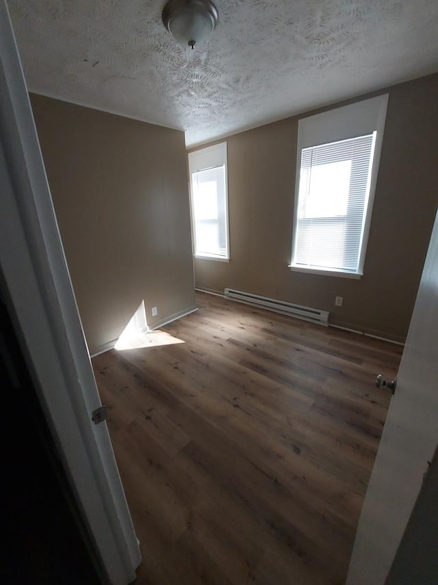 1616 S 7th St, Springfield, IL 62703 - unfurnished room with a baseboard radiator, wood finished floors, a textured ceiling, and baseboards