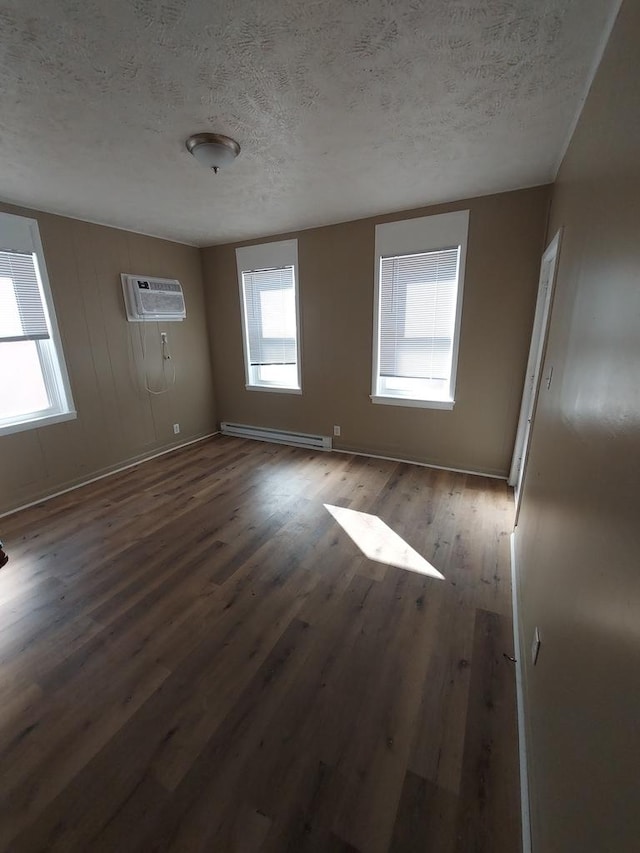 1616 S 7th St, Springfield, IL 62703 - unfurnished room with baseboard heating, a wall mounted air conditioner, wood finished floors, a textured ceiling, and a wealth of natural light