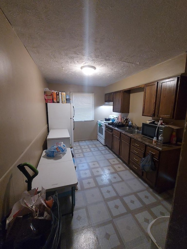 1616 S 7th St, Springfield, IL 62703 - kitchen featuring a textured ceiling, a sink, dark brown cabinetry, white appliances, and light floors