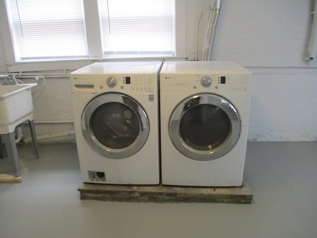 clothes washing area with separate washer and dryer and laundry area