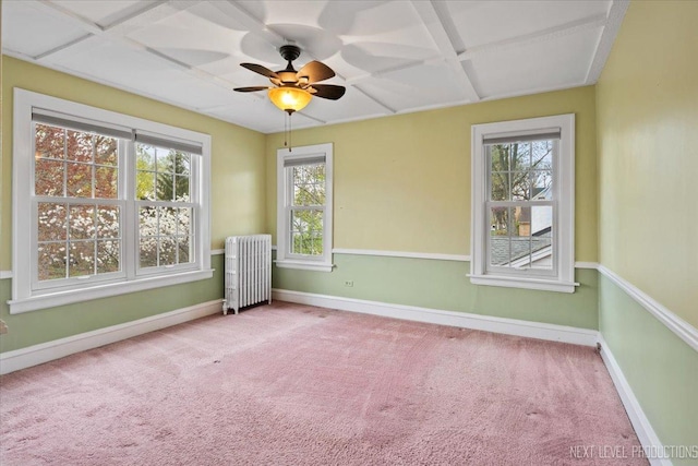 empty room featuring radiator heating unit, ceiling fan, carpet floors, baseboards, and coffered ceiling