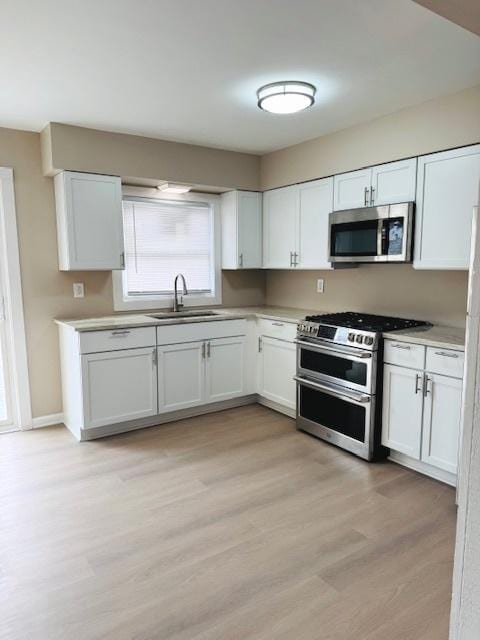 1507 7th St, Winthrop Harbor, IL 60096 - kitchen with stainless steel appliances, light wood-style floors, white cabinets, and light countertops