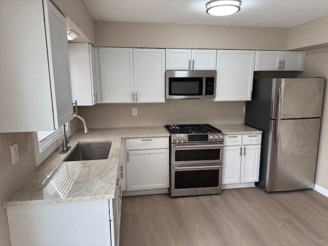 1507 7th St, Winthrop Harbor, IL 60096 - kitchen with appliances with stainless steel finishes, white cabinetry, and light wood-type flooring