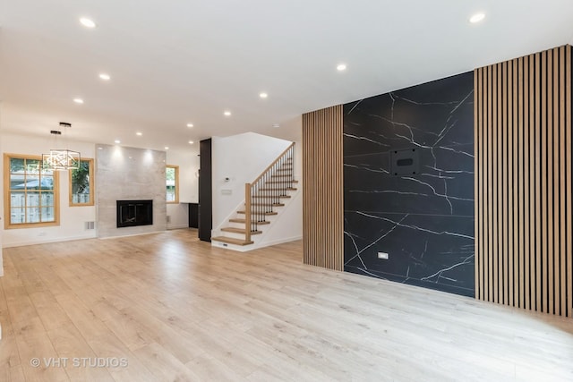 639 Harms Rd, Glenview, IL 60025 - unfurnished living room featuring recessed lighting, stairs, a premium fireplace, and light wood finished floors