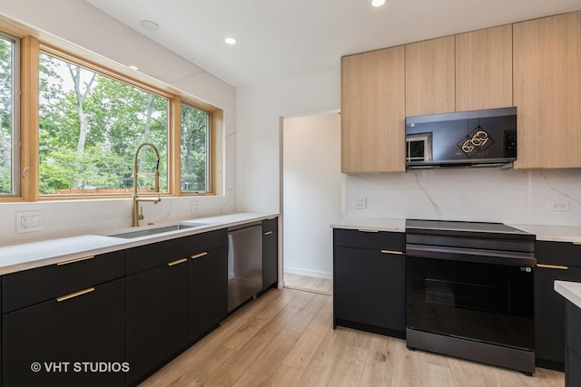639 Harms Rd, Glenview, IL 60025 - kitchen with black range, a sink, light countertops, light wood finished floors, and modern cabinets