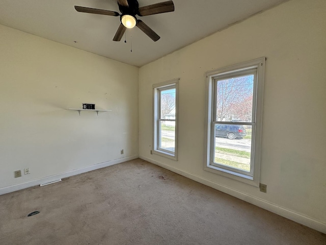 spare room with carpet flooring, baseboards, and ceiling fan