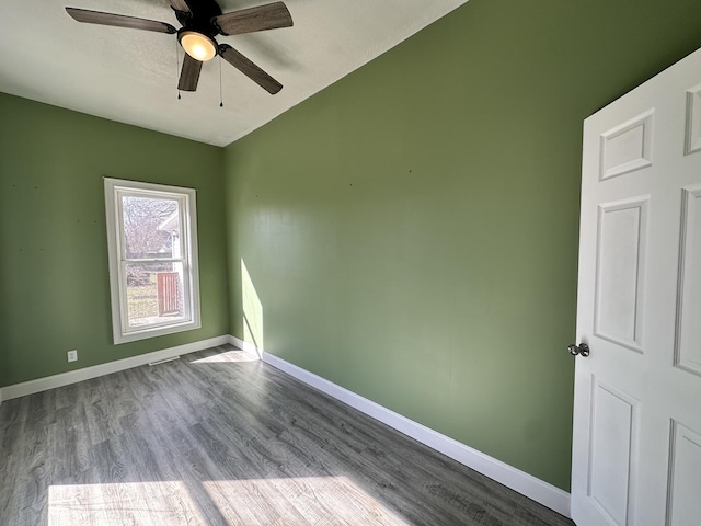 unfurnished room featuring baseboards, wood finished floors, and a ceiling fan