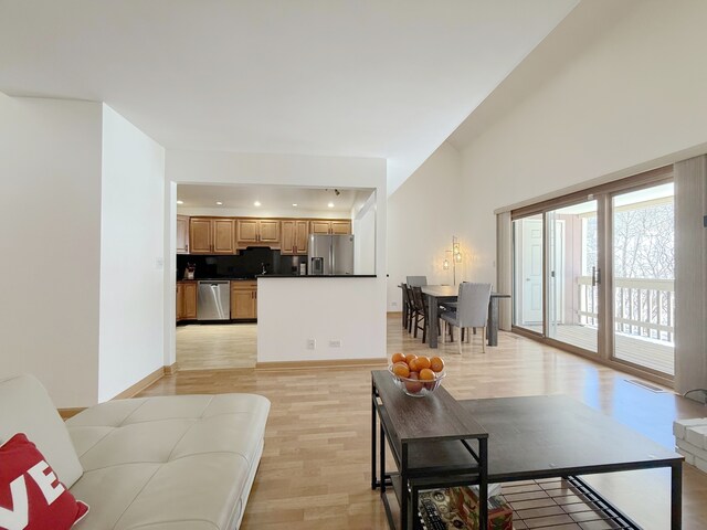 stairway with high vaulted ceiling, wood finished floors, and baseboards